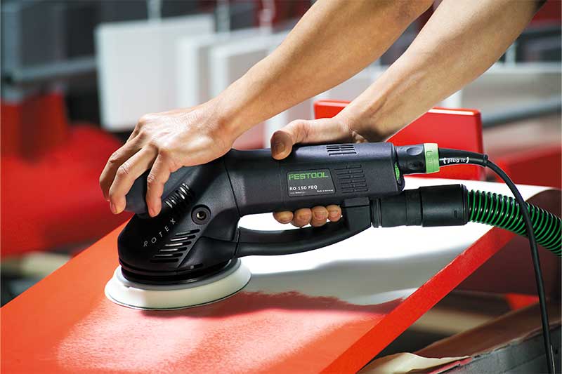 Eine rote Oberfläche wird mithilfe eines Rotex Schleifers bearbeitet